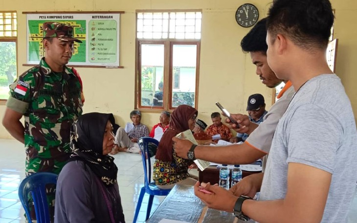 Babinsa Koramil Elikobel saat Dampingi Kepala Kampung Salurkan BPNT dan BST BBM