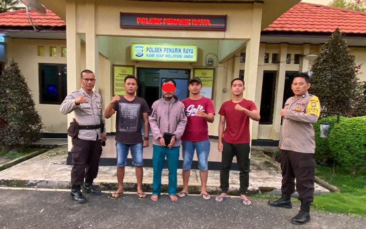 Terduga pelaku (tangan diborgol) saat diamankan polisi
