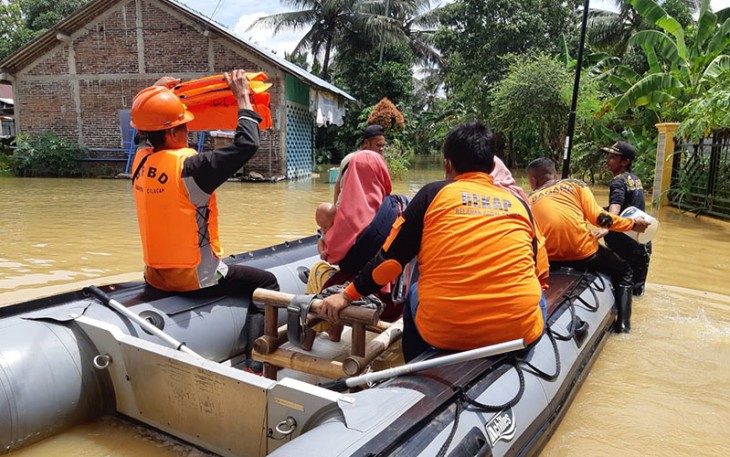 Petugas BPBD setempat saat evakuasi warga terdampak banjir menggunakan perahu karet