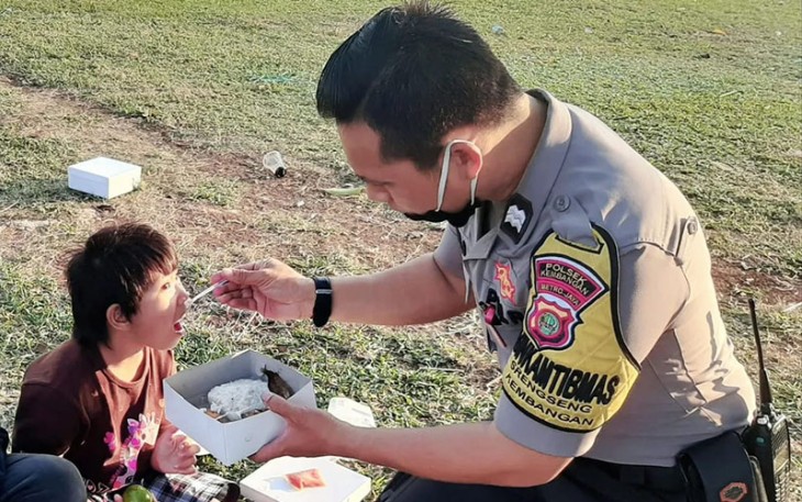 Bhabinkamtibmas Polsek Kembangan saat suapi makanan kepada Anak Berkebutuhan Khusus