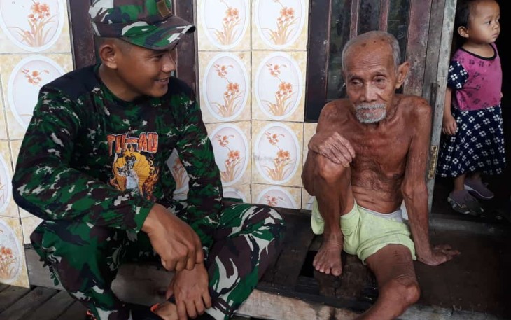 Serma Agus Prayitno, anggota Satgas TMMD Reguler ke 115 saat berkunjung ke rumah Bapak Badrun (90). 