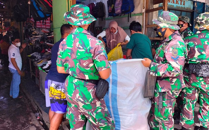 Prajurit Yonmarhanlan VIII Bitung saat membantu para pedagang pasar pindahkan barang dagangannya.