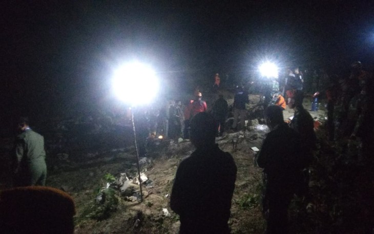 Petugas saat Kumpulkan Serpihan Pesawat yang Jatuh di Desa Nginggil, Senin (18/7/2022) malam.