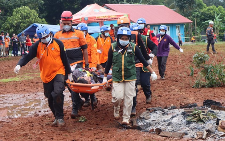 Tim gabungan sedang mengevakuasi korban pada simulasi penanganan gempa dalam rangka peringatan Hari Relawan Sedunia di Buperta Jambore, Depok, Jawa Barat pada Minggu (25/12).