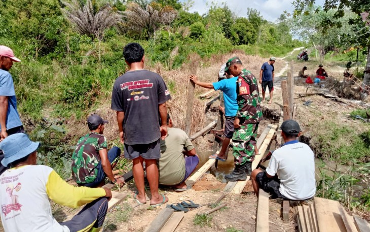 Babinsa Koramil Bukit Batu Bersama Masyarakat Gotong Royong Perbaiki Jembatan  
