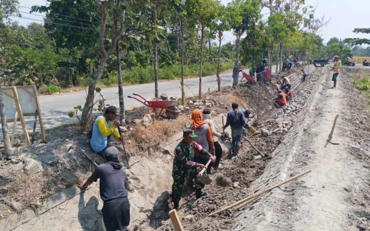 Babinsa Pilangkenceng Bantu Pengerjaan Saluran Irigasi
