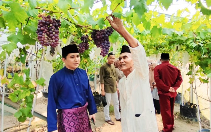 Wakil Bupati Bintan Ahdi Muqsith bersama pemilik anggur mahdinar saat memotong buah Anggur