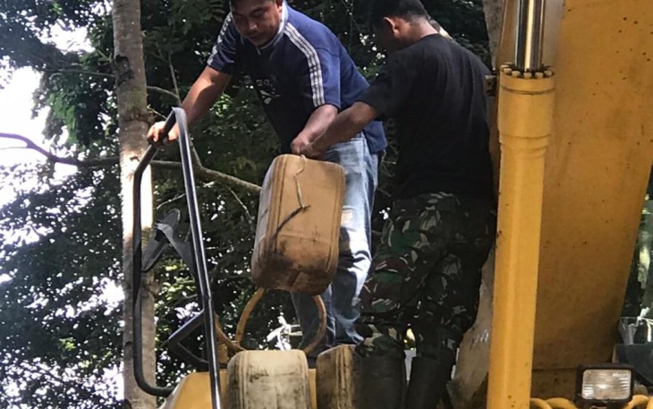 Satgas TMMD saat membantu operator alat berat mengisi BBM