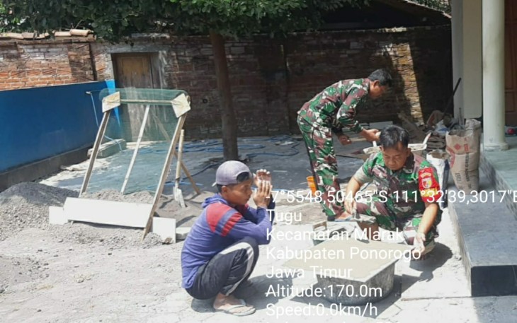 Anggota Kodim 0802/Ponorogo Bantu Warga Pasang Granit Lantai Masjid