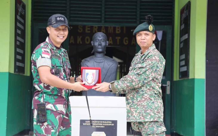 Dansatgas Yonif 645/Gty Letkol Inf Hudallah saat memberikan cenderamata 
