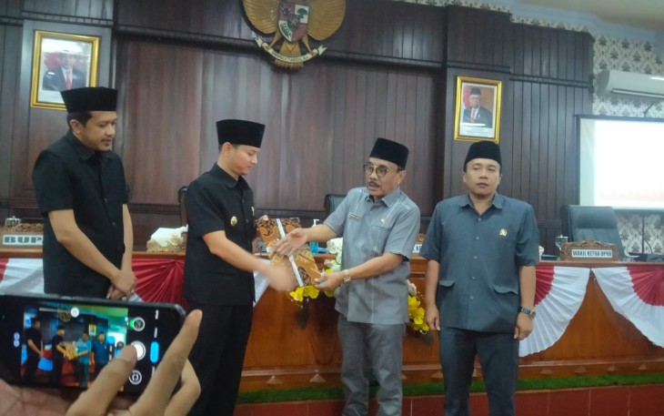 Ketua Dewan Perwakilan Rakyat Daerah (DPRD) Kabupaten Trenggalek, Samsul Anam, saat menyerahkan berkas hasil keputusan DPRD tentang catatan - catatan strategis DPRD atas laporan keterangan pertanggungjawaban (LKPJ) Bupati Trenggalek, akhir tahun anggaran 2022, kepada Bupati Trenggalek, Mochamad Nur Arifin, di gedung graha paripurna DPRD Kabupaten Trenggalek, Kamis (27/4/2023).
