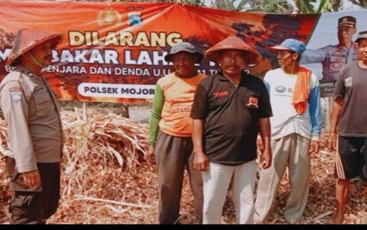 Aipda Sodik saat sosialisasikan dan pasang banner cegah karhutla di wilayah binaan, Rabu (20/9)