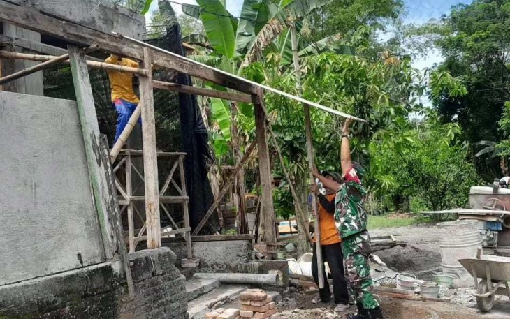 Sertu Jainal membantu pasang asbes rumah warga binaan, Selasa (3/10)