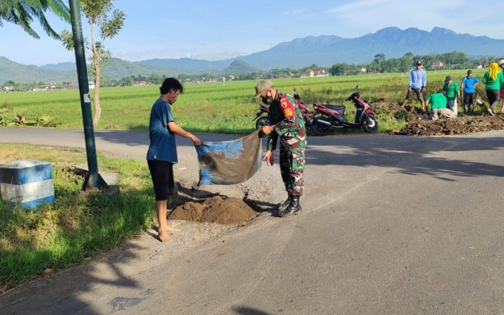 Sertu Zaenal Bersama Warga Membersihkan Saluran Air