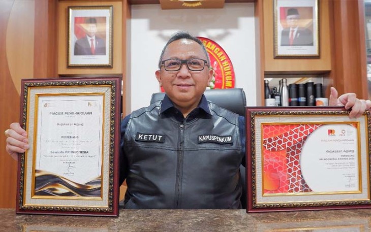 Kapuspenkum Dr. Ketut Sumedana memperlihatkan piagam penghargaan.
