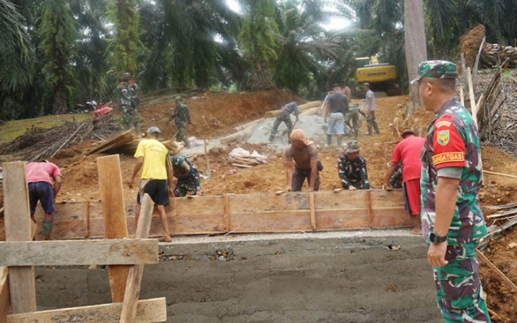 (Dansatgas Letkol Inf. Aswin Suladi, saat meninjau pembangunan infrastruktur jembatan, memastikan kebutuhan material dan pekerjaan lancar)
