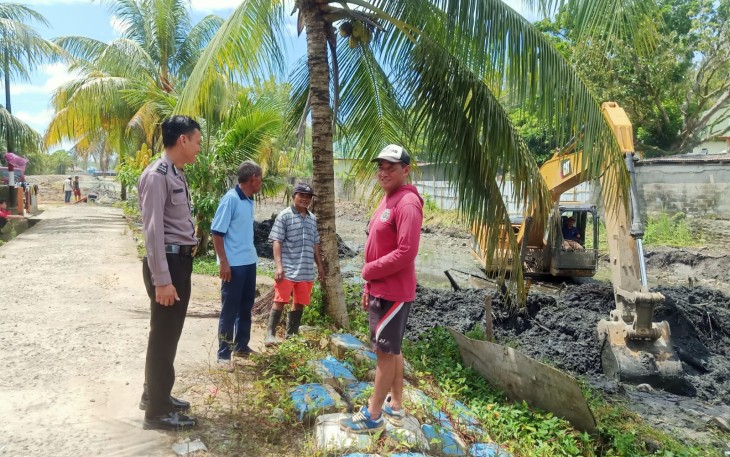 Bhabinkmtibmas Lempuing Bersama Tokoh Masyarakat Pantau Pengerukan Drainase