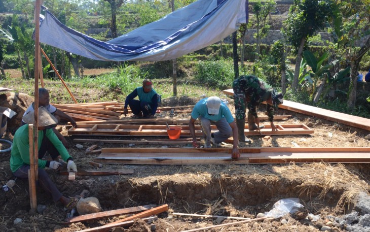 "Anggota Satgas TMMD sedang menyiapkan papan cor"