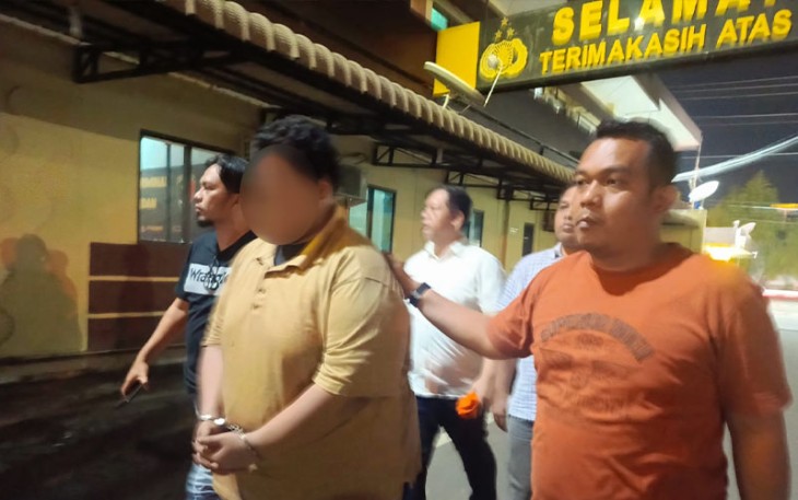 Polisi saat menangkap tersangka (diborgol)