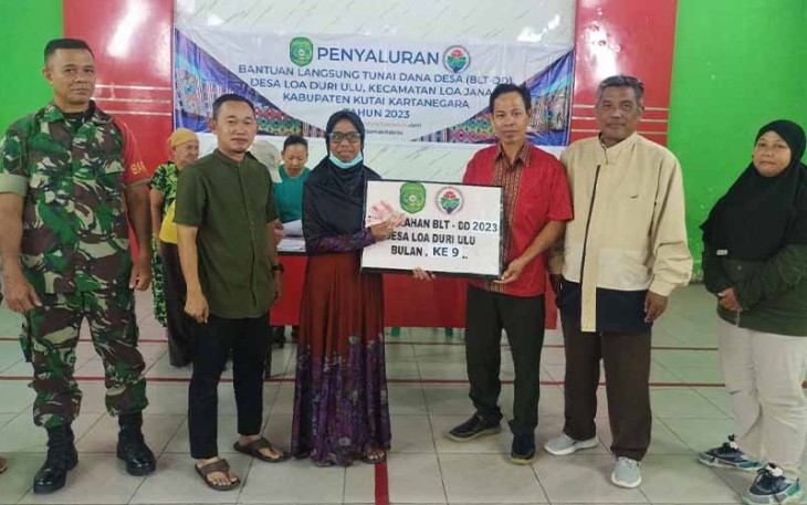 Babinsa Loa Duri Ulu saat Bantu Penyaluran BLT-DD Untuk Warga 