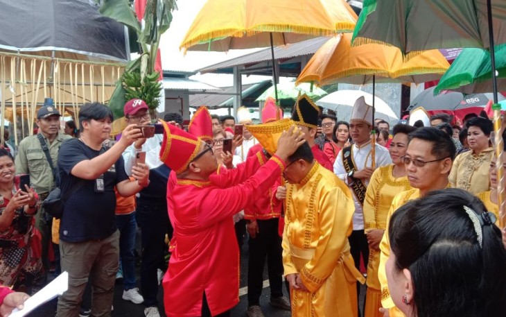 Walikota Bitung saat di pakaikan penutup kepala oleh ketua panitia pelaksana