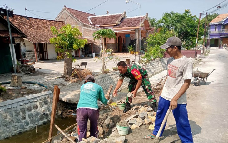 Babinsa Serda Suwarni saat Bantu Masyarakat Bangun Talud