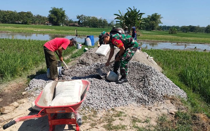 Babinsa Koramil Geger Bantu Warga Bangun Infrastruktur Jalan Sawah.
