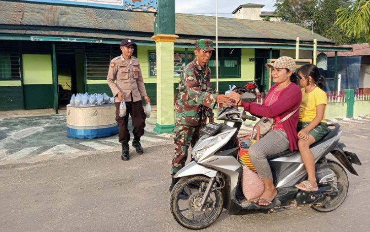 Babinsa Koramil Kahut dan Bhabinkamtibmas saat Bagikan Takjil Gratis Kepada Masyarakat