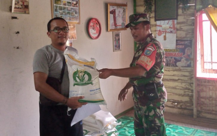 Babinsa Koramil Pahandut Dampingi Penyaluran Bansos Beras dari PT Pos Indonesia 
