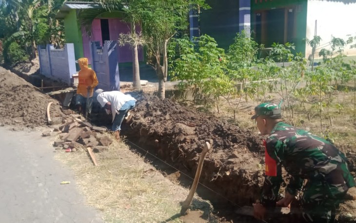 Babinsa Koramil Kebonsari saat Gotong Royong Bersama Warga Perbaiki Saluran Drainase