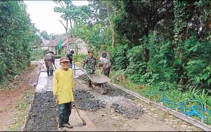 Babinsa Koramil 0801/05 Nawangan, Serma Zaenal Mustofa bersama warga Desa Pakis melaksanakan gotong royong memperbaiki jalan rabat yang berlokasi di Dusun Krajan,Desa Pakis, Kecamatan Nawangan, Kabupaten Pacitan, Selasa (31/12/2024)