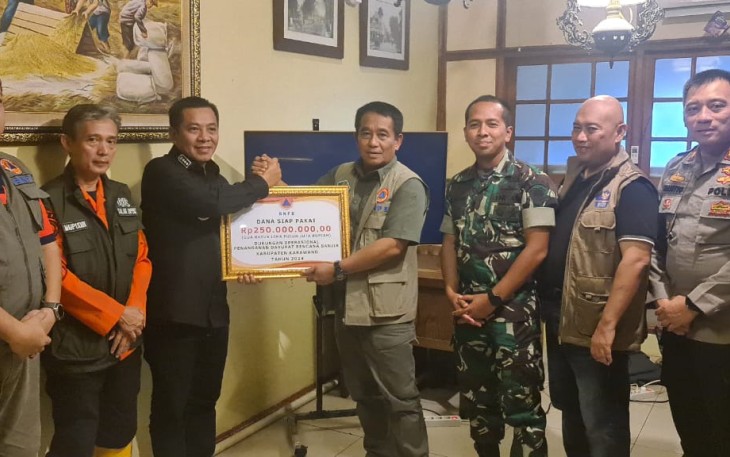Deputi Bidang Penanganan Darurat BNPB Mayjen TNI Fajar Setyawan, S.I.P., secara simbolis menyerahkan bantuan Dana Siap Pakai (DSP) kepada Plt. Bupati Karawang Aep Syapuloh dalam kunjungan ke lokasi pengungsian banjir Kabupaten Karawang, Minggu (7/1). 