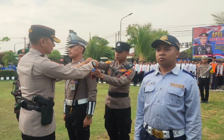 Kapolres Karanganyar AKBP Jerrold Hendra Yosef Kumontoy menyematkan pita kepada personel saat Apel Gelar Pasukan Operasi Zebra Candi 2024 di Mapolres Karanganyar, Senin (14/10/2024)