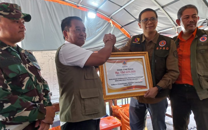 Deputi Bidang Penanganan Darurat BNPB Mayjen TNI Fajar Setyawan, S.I.P. (baju putih dengan rompi) secara simbolis memberikan dukungan bantuan penanganan bencana kepada Sekretaris Daerah Kabupaten Bandung di Kecamatan Rancaekek, Kabupaten Bandung, Jawa Barat, Jumat (23/2).
