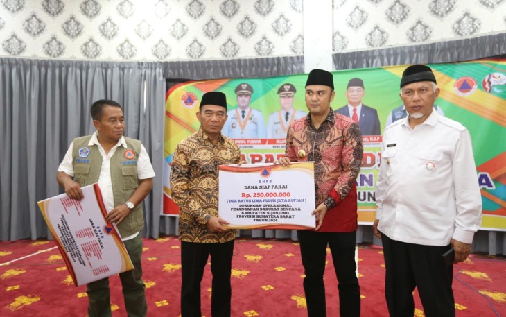​​Menko PMK Muhadjir Effendy (dua kiri) menyerahkan dukungan Dana Siap Pakai (DSP) secara simbolis kepada Bupati Sijunjung Benny Dwifa Yusfir (dua kanan) disaksikan Deputi Bidang Penanganan Darurat BNPB Fajar Setyawan (kiri) dan Gubernur Sumatera Barat Mahyeldi Ansharullah (kanan) di Rumah Dinas Bupati Sijunjung, Sumatera Barat, Jumat (26/4).