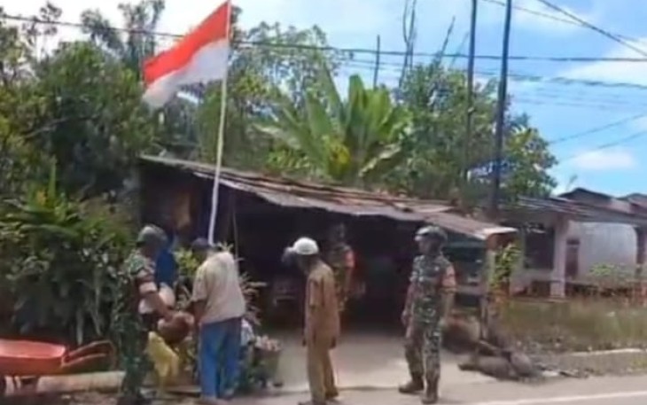 Satgas TMMD Menghimbau Warga Kibarkan Bendera Merah Putih.