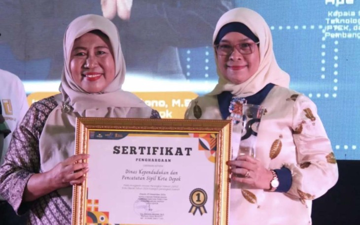 Kepala Disdukcapil Kota Depok Nuraeni Widayatti (kiri) saat menerima penghargaan Anugerah Inovasi Perangkat Daerah dalam rangkaian acara Depok Media Arts Summit 2024 dari Penjabat (Pj) Sekretaris Daerah (Sekda) Kota Depok Nina Suzana
