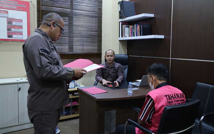 Tersangka (kenakan baju tahanan) saat akan ditahan