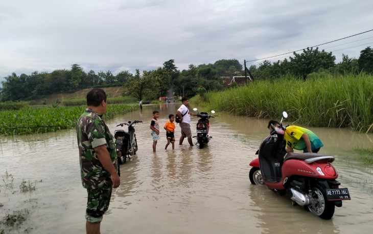 Babinsa Posramil Pitu Kodim 0805/Ngawi Serma Eko bersama Bhabinkamtibmas melaksanakan Pemantauan banjir luapan sungai bengawan Solo yang melintasi daerah tersebut, guna mengantisipasi ketinggian air