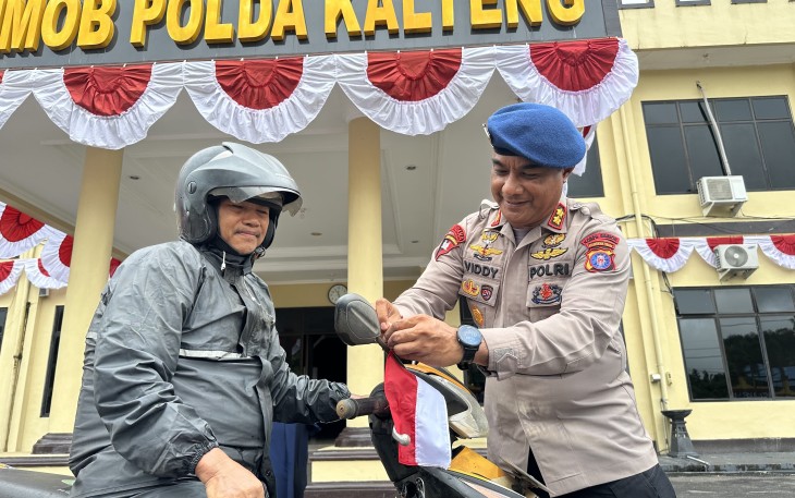 Brimob Kalteng Bagikan Ratusan Bendera Merah Putih ke Pengguna Jalan Raya