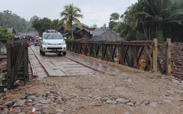 Kendaraan roda empat melintas di jembatan baily dari arah Provinsi Tapanuli Tengah menuju Tapanuli Selatan via Desa Garoga, Batang Toru pada Minggu (14/12)