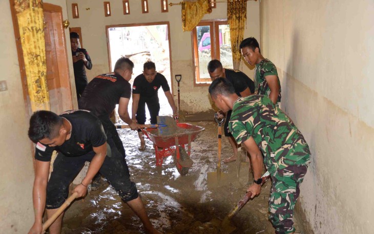Bersihkan lumpur di dalam rumah warga 