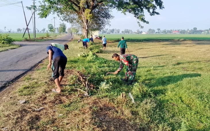 Babinsa Pilangkenceng Bersama Warga saat Gotong Royong Bersihkan Jalan Desa