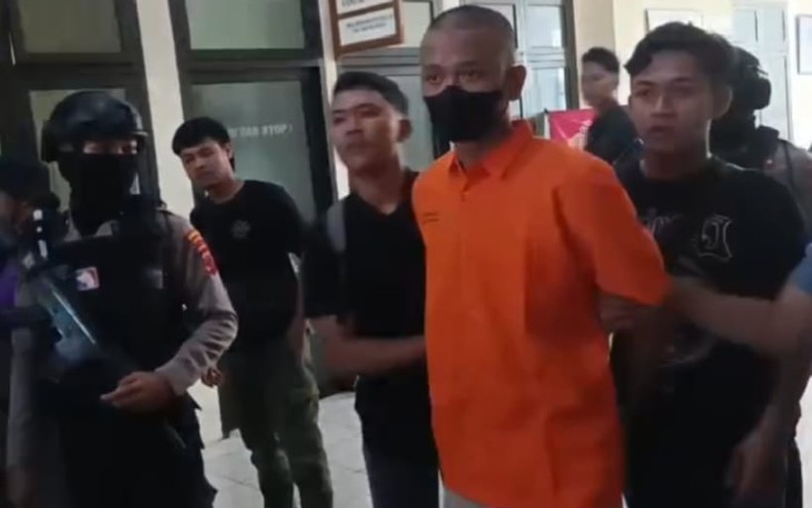 IFR (22), tersangka kasus pembobol brankas gudang PT Marga Nusantara Jaya, saat dibawa aparat kepolisian Polres  Karanganyar, Selasa (7/10/2025).
