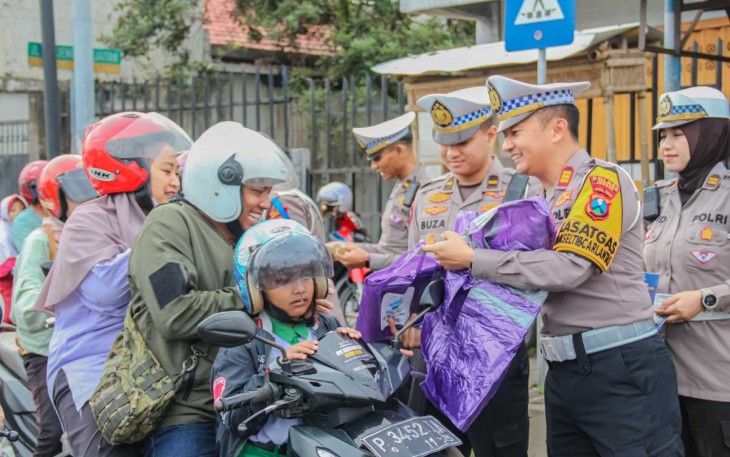 Kasat lantas Polres Jember AKP Bernardus Bagas saat membagikan jas hujan, Senin (10/2)