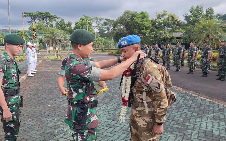 Danyonkes 2 Kostrad Letkol Ckm dr. Ucok Harianto mengalungkan bunga purna tugas Sertu Priyan Setyawan, Senin (28/4)