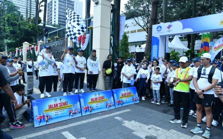 Mendikdasmen Abdul Mu'ti mengibarkan bendera dimulainya jalan sehat Hardiknas 2025 di Jakarta, Minggu (18/5)