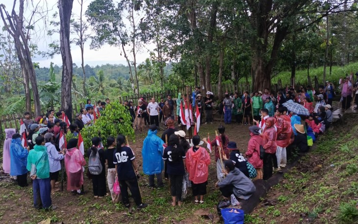Siswa SMP Kebangsaan Bharata peserta napak tilas berkumpul mengelilingi replika tongkat Pengeran Sambernyawa di lokasi Punden Sono, Dusun Dawung, Desa Kedawung, Kecamatan Jumapolo, Rabu (5/11/2025)