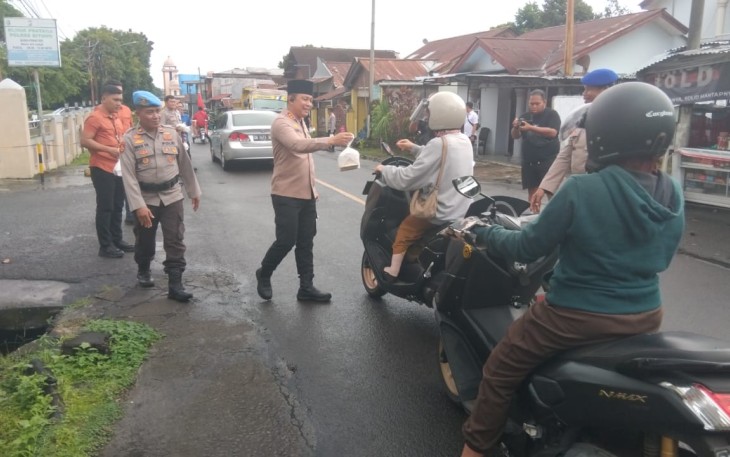 Kapolres Bitung, AKBP Albert Zai, SIK.,MH saat membagikan takjil kepada pengendara yang sedang menjalankan ibadah puasa