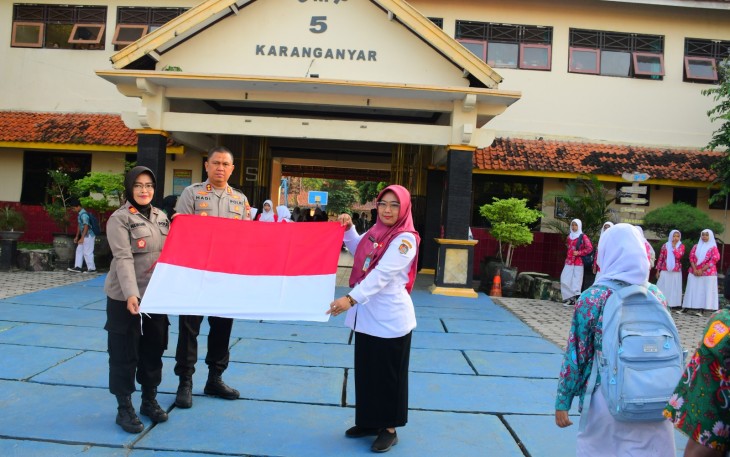 Kapolres Karanganyar, AKBP Hadi Kristanto, didampingi Kapolsek Karanganyar, AKP Nawangsih Retno Waruju, saat membagikan bendera merah putih di SMP 5 Karanganyar, Rabu (6/8/2025) pagi.